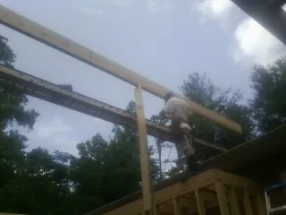 Carpenter setting a ridge beam over a new addition frame — Ice Dam Removal by Roofing Brothers in Letha