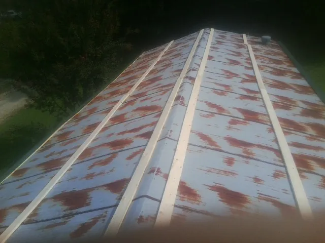 Rusted metal roof panels with new wood purlins before replacement — Storm Damage Roof Repair in Letha by Roofing Brothers