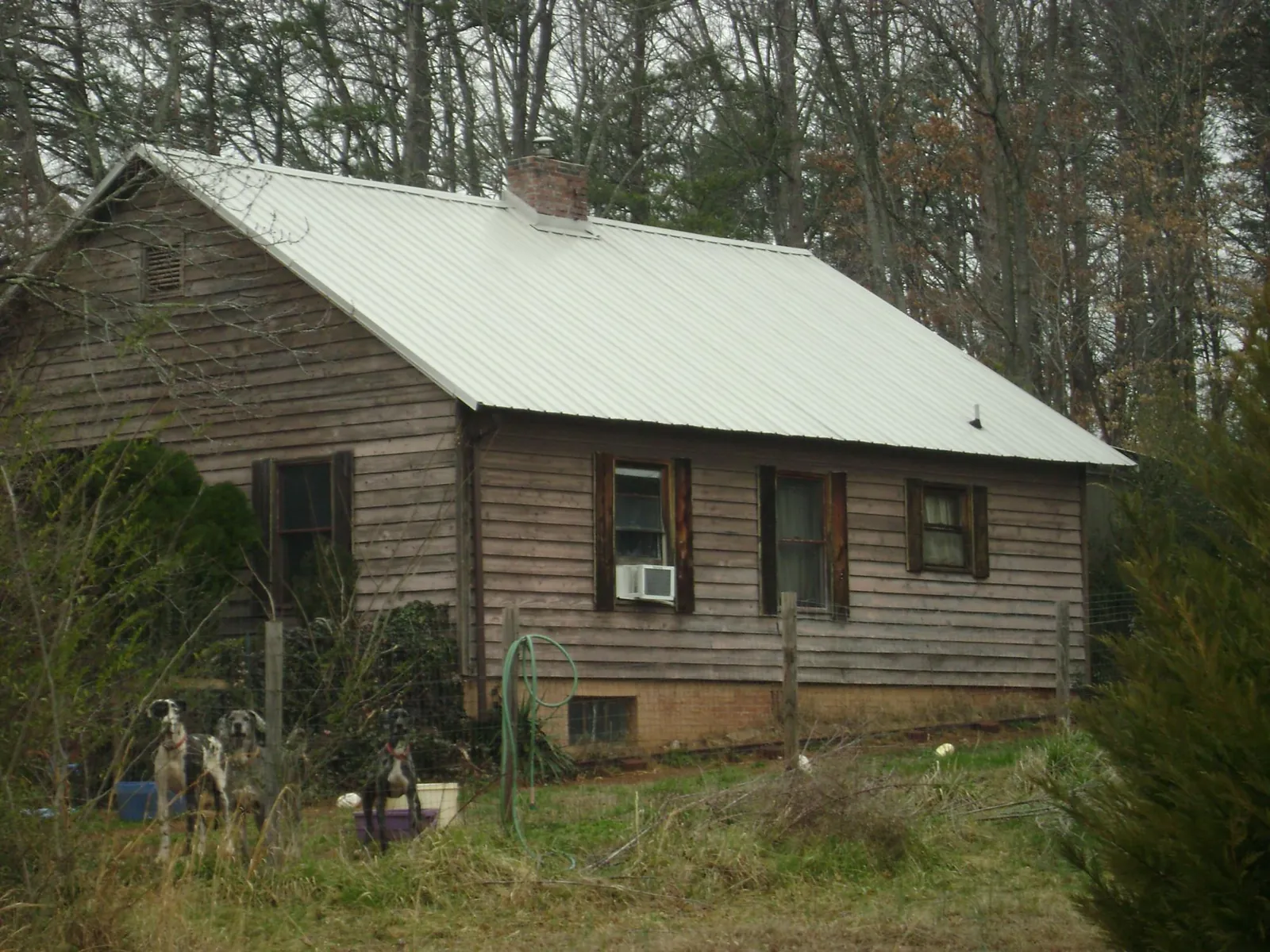 White metal roof on an old wood sided farmhouse, from a Metal Roof Installation job in Letha